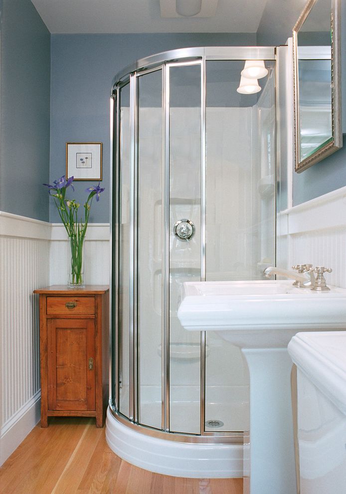 Average Cost to Remodel a Small Bathroom   Traditional Bathroom Also Blue Wall Glass Shower Light Wood Wall Pedestal Sink Small Bathroom Mirror Wall Sconce White Wainscoting Wood Side Table