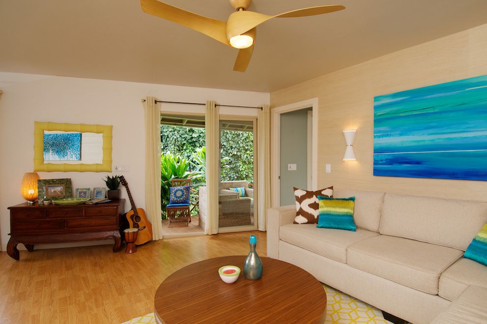 Ceiling Fan with Good Lighting   Tropical Living Room  and Beige Curtains Ceiling Fan Cream Sectional Cream Sofa Dark Wood Dresser Grass Cloth Wall Guitar Light Wood Floor Wall Sconce White Wall Wood Coffee Table Yellow Frame Mirror Yellow Patterned Rug