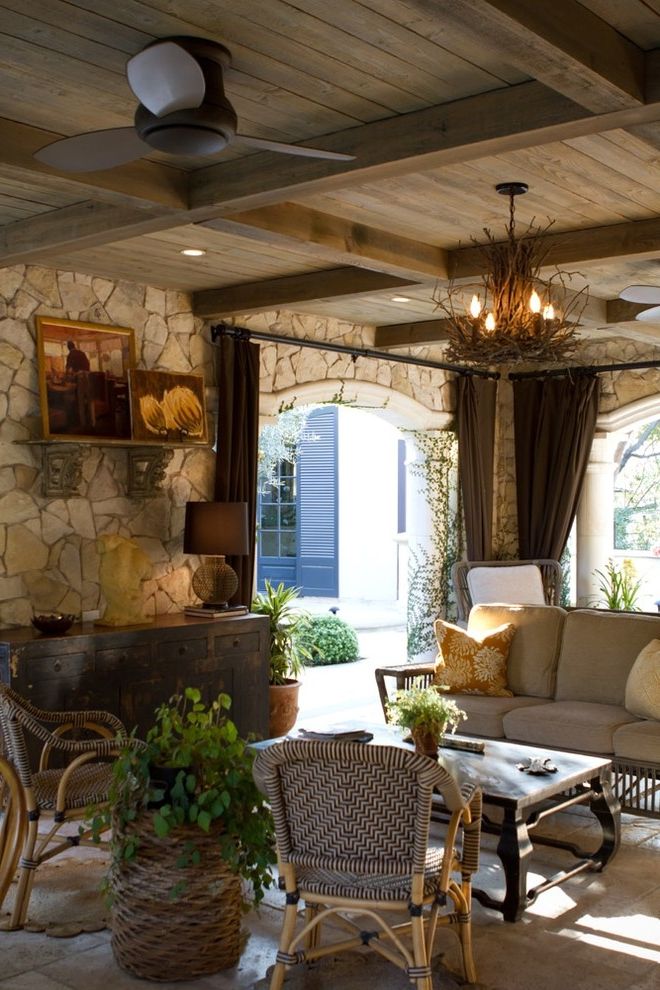 Chandelier with Ceiling Fan Attached   Rustic Patio Also Cane Chairs Ceiling Fan Chandelier Credenza Curtain Panels Outdoor Curtains Rustic Stone Walls Tile Floor Travertine Floors Wicker Basket Wicker Sofa Wood Ceiling Woven Chairs
