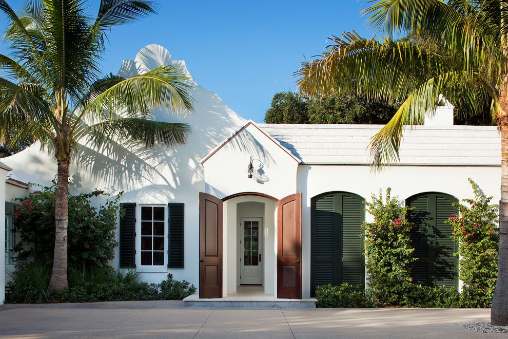 Chowning Heating and Cooling   Tropical Exterior Also Arched Front Door Bushes Entryway Green Shutters Outdoor Lighting Palm Tree Red Flowers Shrubs Unique Exterior White Exterior White Roof White Siding Wood Front Door