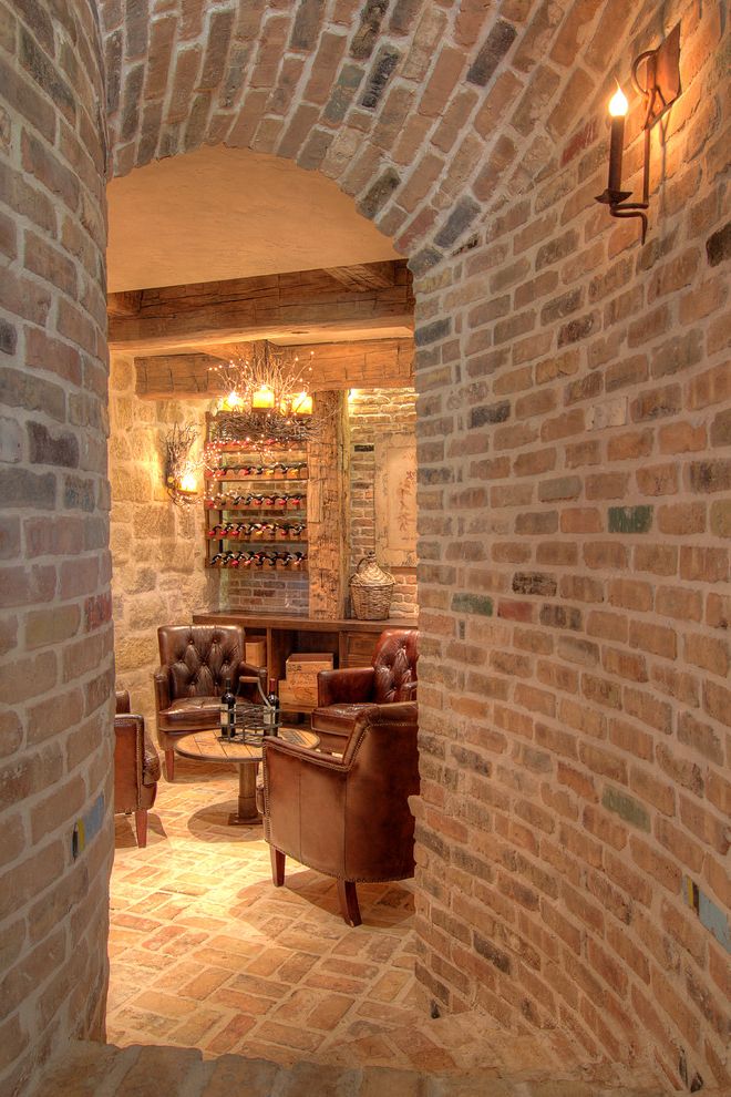 Distressed Leather Club Chair   Mediterranean Wine Cellar  and Antique Wall Sconce Barrel Vault Brick Wall Brown Leather Club Chair Curved Wall Leather Club Chair Rustic Chandelier Wine Crates Wineroom