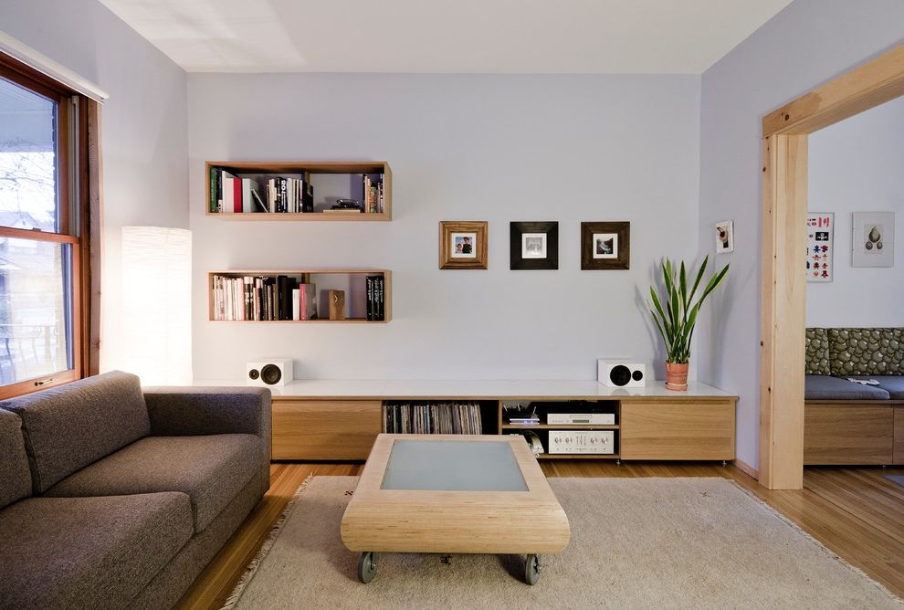 Floating Floor Lowes with Modern Living Room  and Area Rug Banquette Seating Brown Sofa Coffee Table on Casters Floating Bookshelves Floor Lamp Gray Walls Knotty Lumber Music Speakers Wood Floor Wood Trim