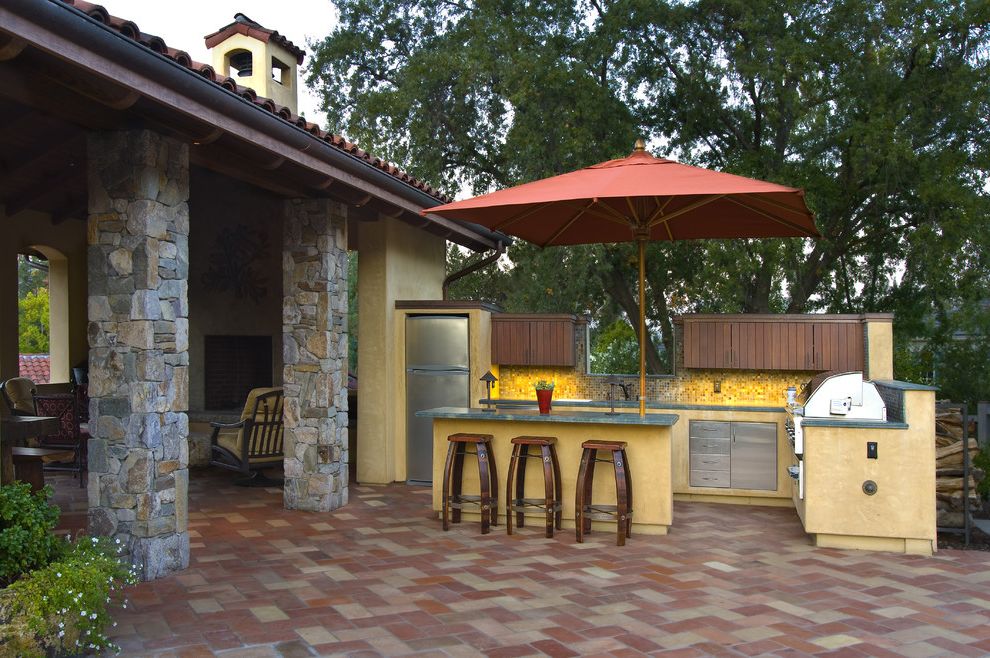Gladiator Flooring with Mediterranean Patio Also Counter Stools Covered Patio Outdoor Kitchen Stainless Steel Stone Posts Stucco Tile Floor Tile Roof Umbrella