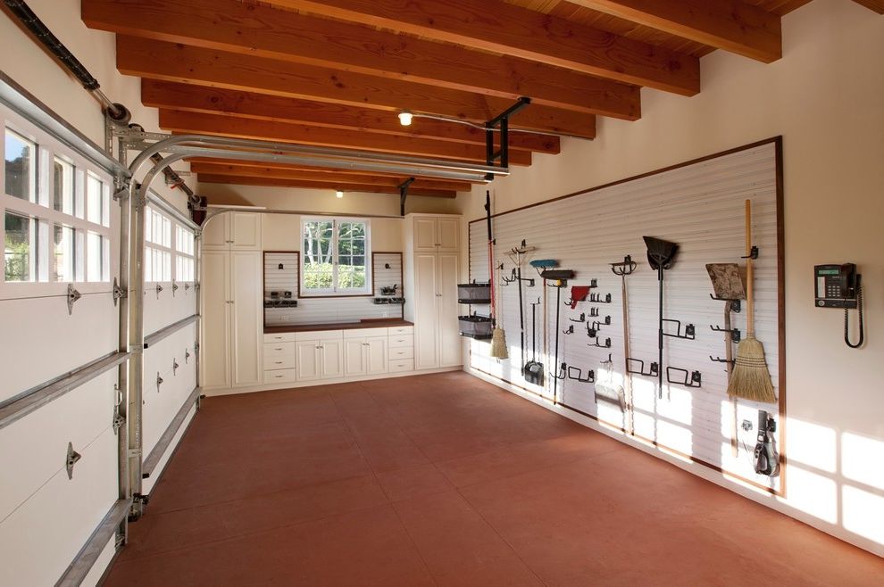 Gladiator Flooring with Traditional Garage  and Bench Built in Cabinets Ceiling Light Cement Floor Earth Tones Garage Door Garage Storage Tool Rack White Wall Window Wood Beams