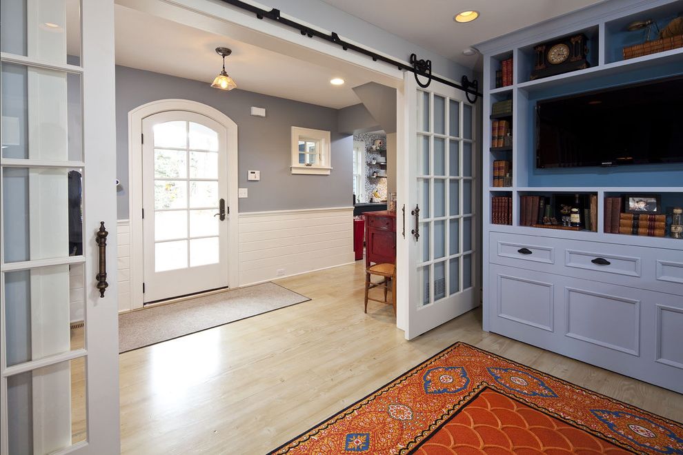 Indoor Barn Doors with Traditional Entry Also Arched Door Bookshelves Built in Cabinets Entry Glass Doors Gray Natural Wood Floor Orange Area Rug Sliding Doors Tv Wainscot White Painted Trim