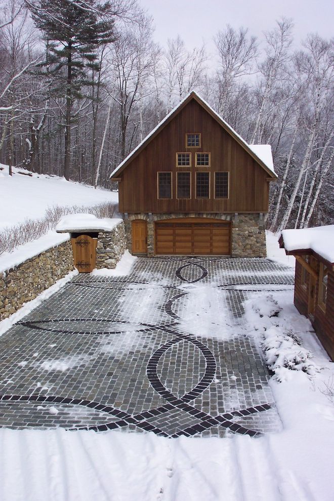 Paver Driveway Cost   Rustic Garage  and Cabin Cobble Drive Decorative Pattern Driveway Gable Roof Hardscape Jumbo Cobbles Muntins Natural Landscape Pavers Snow Snow Melt System Stacked Stone Fence Trees Windows Winter Courtyard Wood Garage Door