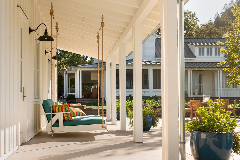 Porch Swings for Sale with Farmhouse Porch  and Calm Columns Contemporary Farm House Modern Farm House Napa Valley Outdoor Living Outdoor Pillows Outdoor Sconces Planters Relaxing Swinging Porch Bed Tranquil White Farm House Wine Country
