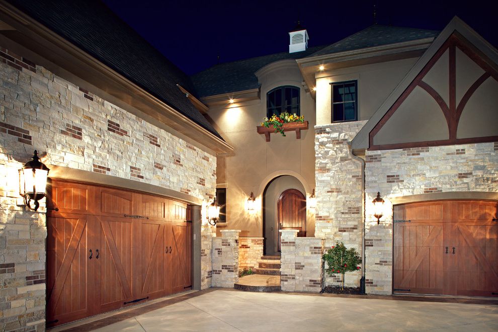 Renaissance Norman Ok   Traditional Exterior  and Arched Doorway Brick and Stone Carriage Doors Courtyard Front Entrance Garage Door Stacked Stone Stone Trusses Window Box