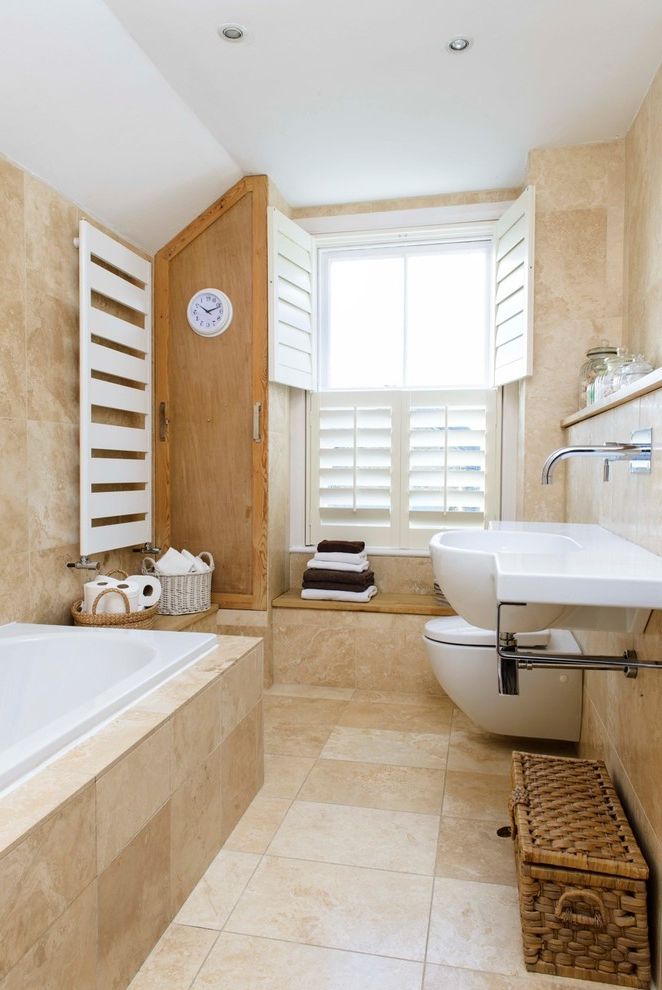 What is Travertine Tile with Beach Style Bathroom Also Airy Bright Coastal Cottage Coastal Decor Coastal Home Light Open Plantation Shutters Seaside Towel Warmer