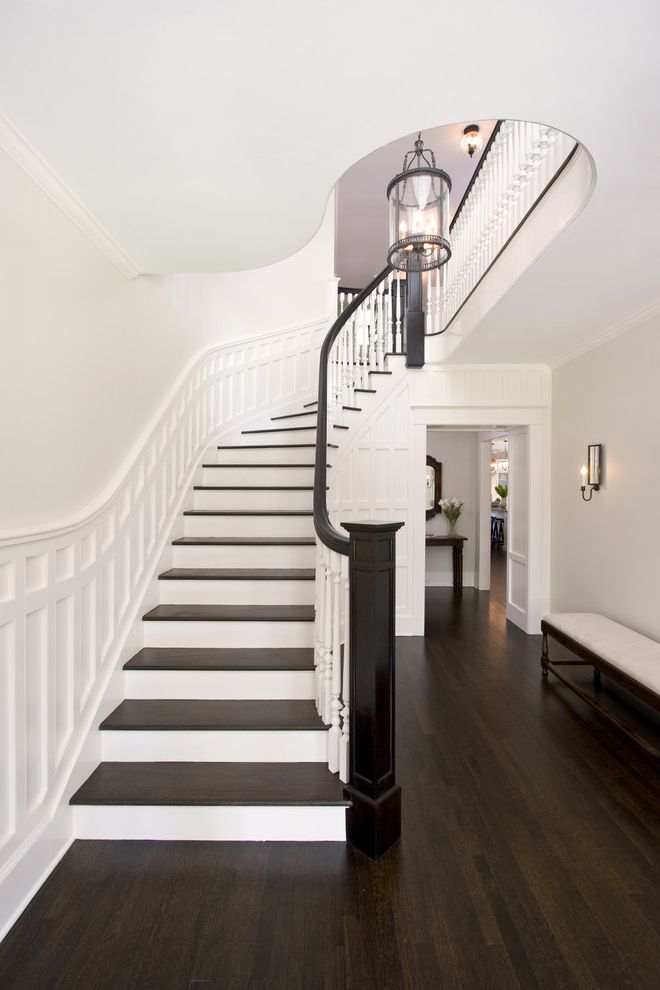 Which Way to Lay Wood Floor   Traditional Staircase Also Banister Curved Staircase Dark Floor Entrance Entry Entry Lantern Foyer Wainscoting White Wood Winders Wood Flooring Wood Molding Wood Railing Wooden Staircase