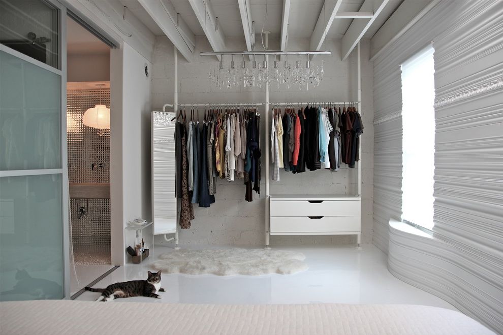 The Container Store Closet Systems   Contemporary Closet  and Cinder Block Walls Curved Walls en Suite Exposed Rafters Linear Chandelier Loft Master Bedroom Monochromatic Open Closet Sheepskin Rug Textured Walls White Bedroom White Floor