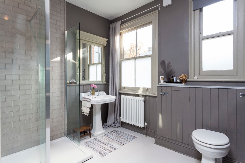 Tile Shop Coon Rapids   Scandinavian Bathroom  and Framed Mirror Gray Curtains Gray Wainscoting Radiator Rag Rug Tankless Toilet