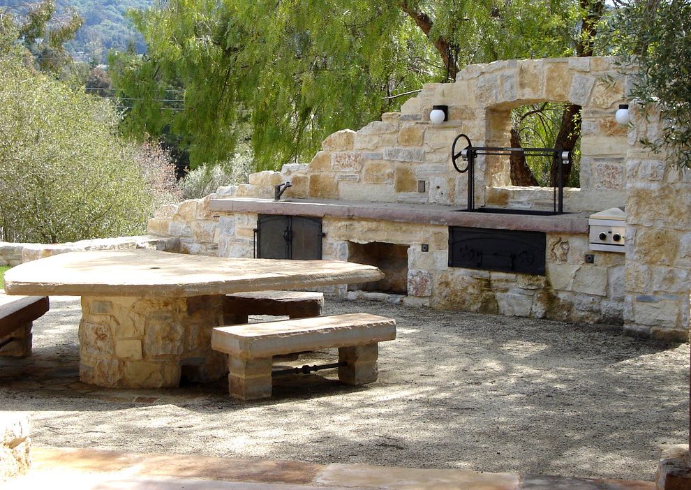 Bar B Que Grills with Mediterranean Patio  and Bench Entertaining Flagstone Gravel Grill Hardscaping Landscaping Neutral Colors Outdoor Dining Outdoor Furniture Outdoor Kitchen Sconce Stacked Stone Table Trees