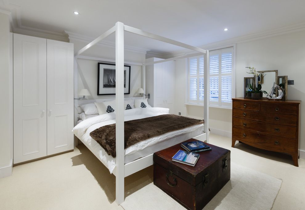 Yacht Bedding with Traditional Bedroom  and Beige Floor Brown Fur Throw Built in Armoires Dark Wood Dresser Dark Wood Trunk White Armoire White Bedding White Bedroom White Dresser White Four Poster Bed White Throw Pillow White Wall White Window Trim