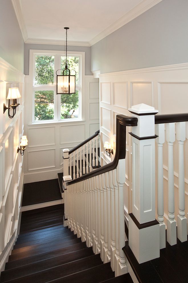 The Ordinary Charleston with Traditional Staircase  and Crown Molding Dark Stained Railing Dark Stained Wood Floor Frame and Panel Woodwork Gray Walls Lanterns Spindles Wall Sconce White Painted Paneling